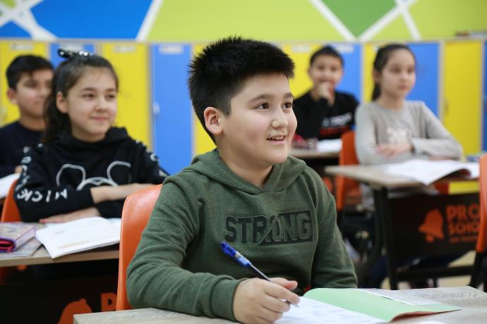 boy in gray long sleeve shirt holding pen